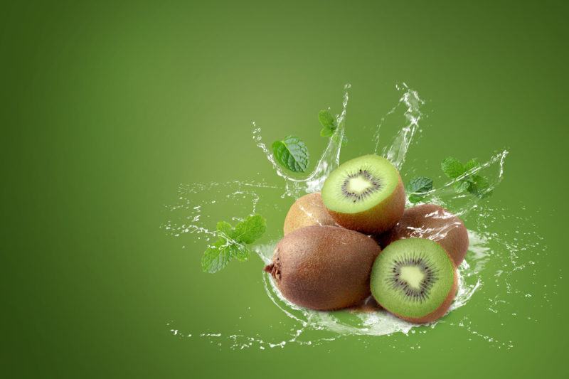 Water splashing on kiwi fruit and half kiwi