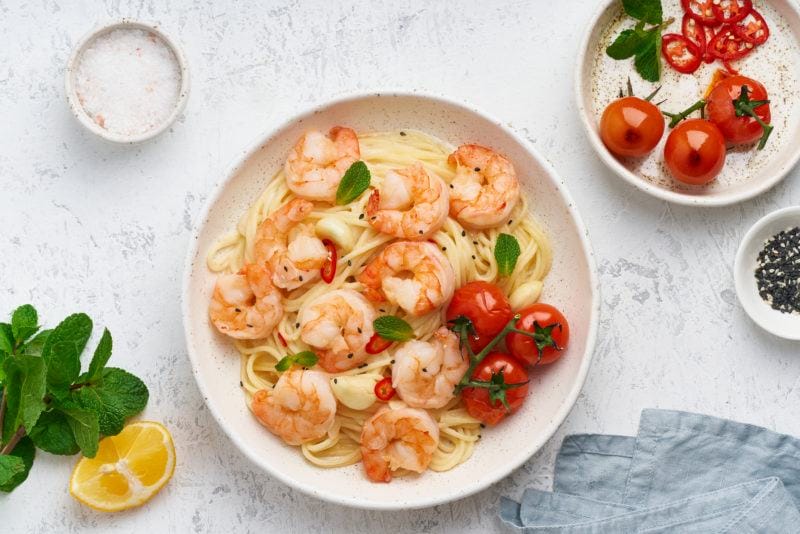 Pasta Bavette With Fried Shrimps, Bechamel Sauce, Mint Leaf, Garlic, On White Plate, Top View