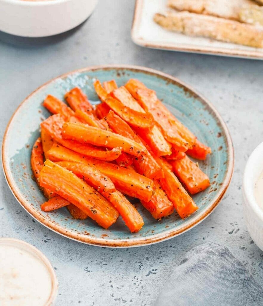 Vibrant carrot fries laid out, awaiting their young gourmand.