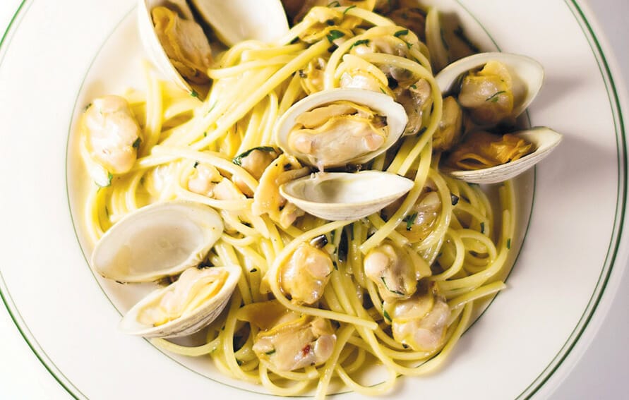 Image Of The Finished Dish Alongside A Wine Glass: &Quot;Elevate Your Dining Experience With The Ultimate Pairing—A Glass Of Wine And Our Divine White Clam Sauce Spaghetti.&Quot;