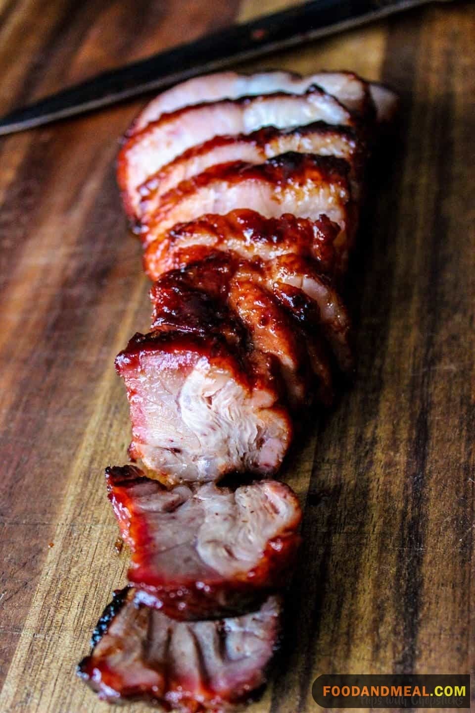 The Elegant Presentation Of Char Siu Pork, Featuring Its Distinct Dark Black Outer Layer And Contrasting White Inner Meat.